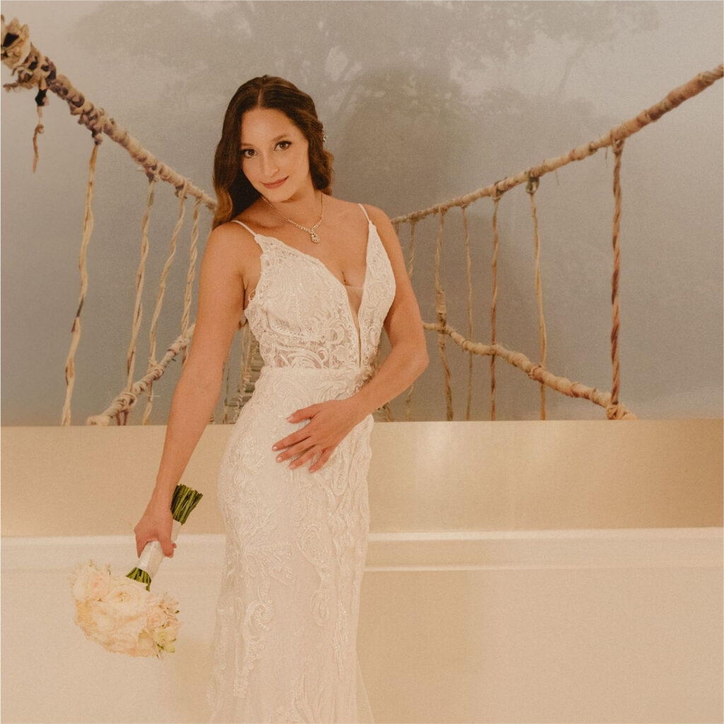 Bride smiling brightly while holding bouquet with radiant makeup